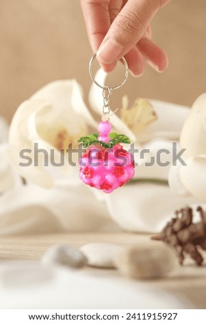 Handmade key chains are unique, small, beautiful and colorful. looks like it is held against an aesthetic background