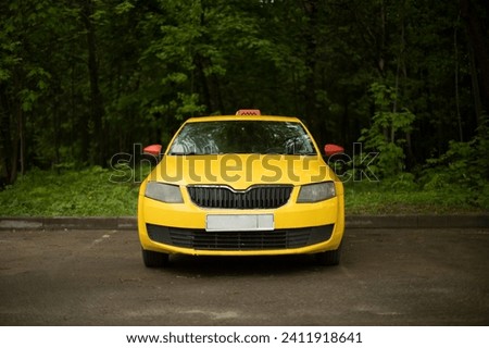 Yellow taxi in parking lot. Car is in front. Yellow car. Taxis in city.