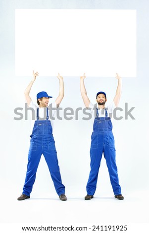 Two employees holding a blank banner