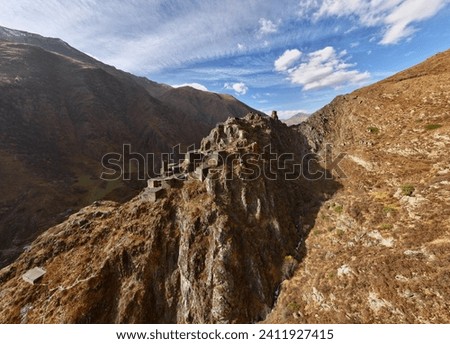 Aerial view of Mutso Fortress made of stones in Khevsureti region Georgia, mountain view and an ancient castle merges with the mountains and canyon, beautiful historical ruins