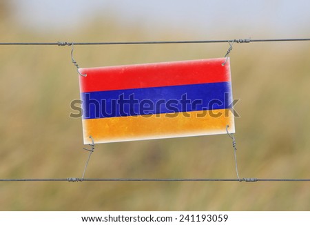 Border fence - Old plastic sign with a flag - Armenia