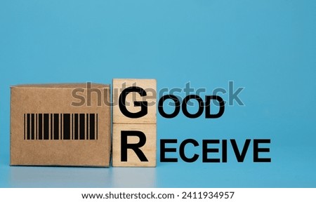 A picture of carton box with barcode, wooden block G, D and Good Receive word. Royalty-Free Stock Photo #2411934957