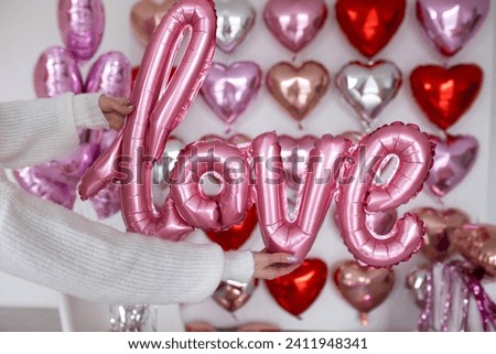 Festive decorations for Valentine's day, wedding or hen party. Love sign and heart shape balloons on white background.