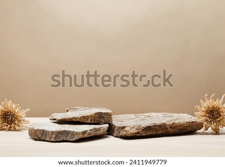 Luxury Brown stone marble pedestal Podium decoration with dried flower Over Beige Background. elegant backdrop product showcases and sophisticated designs for Skin care and cosmetic Exhibition . Royalty-Free Stock Photo #2411949779