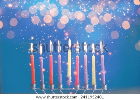 Hanukkah celebration. Menorah with burning candles on blue background with blurred lights, closeup