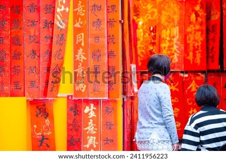 The Chinese Spring Festival streets sell calligraphers handwritten Spring Festival couplets (text: good luck, good things, blessing, spring) Royalty-Free Stock Photo #2411956223