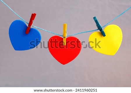 Colored hearts attached to rope with clothespins