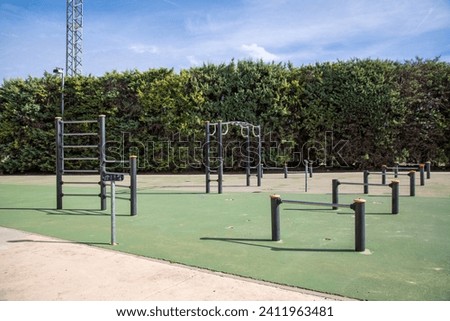 Public sports equipment for general training. Mainly rack bars and similar. The floor is green. The floor is covered with green artificial grass. Royalty-Free Stock Photo #2411963481
