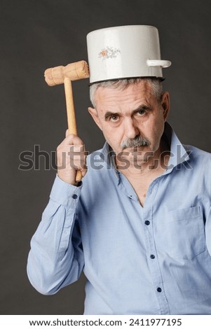 A man tries to reach his consciousness with a hammer through a saucepan placed on his head