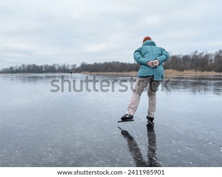 High quality photo of a single ice skater, rider, on frozen ice lake in winter in Friesland, the Netherlands