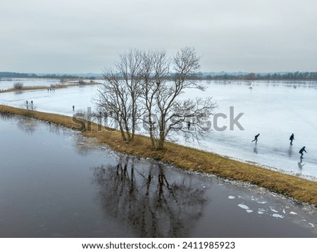 High quality aerial drone photo of people ice skating on a frozen lake in winter near Sneek, Friesland, the Netherlands