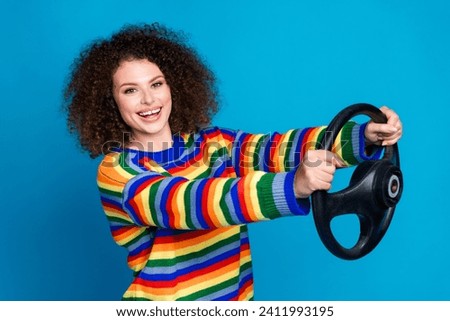 Photo portrait of lovely young lady steering wheel cheerful driver wear trendy rainbow print garment isolated on blue color background