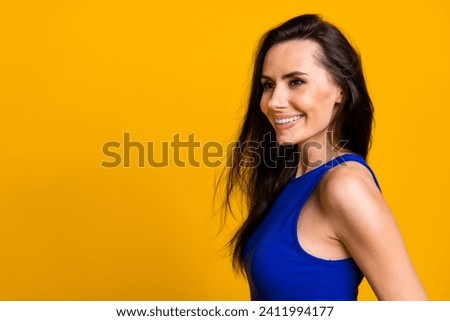 Photo of shiny cheerful lady dressed blue top smiling looking empty space isolated yellow color background