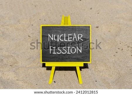 Nuclear fission symbol. Concept words Nuclear fission on beautiful black chalk blackboard. Chalkboard. Beautiful sand background. Business science nuclear fission concept. Copy space. Royalty-Free Stock Photo #2412012815