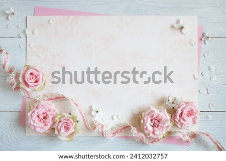 White and pink paper with flowers of pink roses, blooming cherry plum, lace ribbon for text greeting, invitation. Card for wedding, Mother's day, birthday