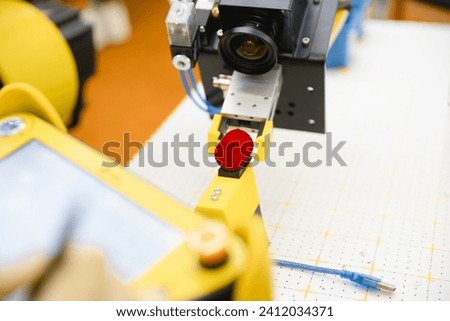 A robot in a laboratory equipped with a machine vision camera works with hazardous substances. Royalty-Free Stock Photo #2412034371