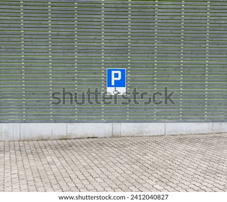 Disabled parking lot with blue traffic sign, blue and white, only people with a physical disability may park here, during the day without people