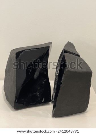 white Empty podium. black stones, Empty product shelf standing in the background. Stone on a black background in the studio with texture