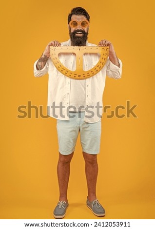positive man hold geometry protractor isolated on yellow. man hold geometry protractor