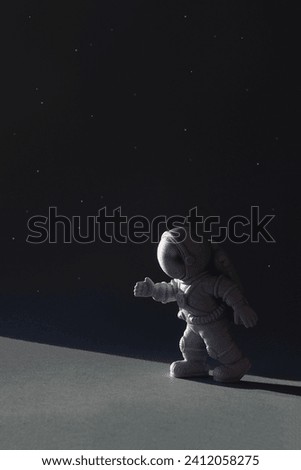 Figure astronaut on dark background. World Space Week vertical banner. Selective focus, copy space