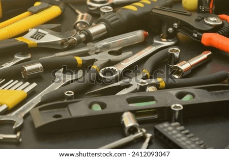 Handyman tool kit on black wooden table. Many wrenches and screwdrivers, pilers and other tools for any types of repair or construction works. Repairman tools set Royalty-Free Stock Photo #2412093047