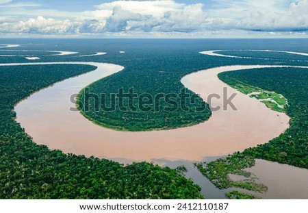 Aerial view of the Amazon River winding through dense forests in Amazonas, Colombia Royalty-Free Stock Photo #2412110187