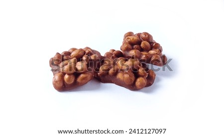 Close up of Ting-ting or Enting-enting or Ampyang isolated on white background. Traditional Indonesian sweet snack made from peanuts mixed with brown sugar. Clipping path.  Royalty-Free Stock Photo #2412127097