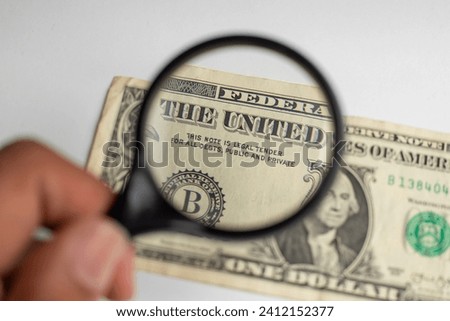Close up of US one dollar bill isolated on white background, magnifying glass on one dollar bill