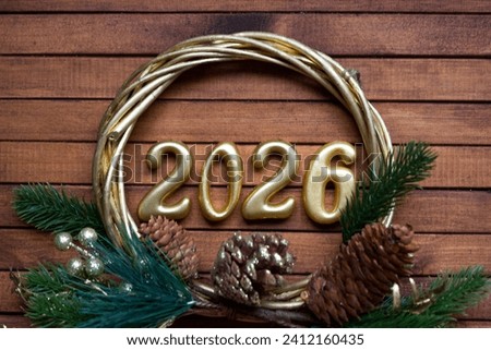 Happy New Year golden numbers 2026 on cozy festive brown wooden background with sequins, snow, lights of garlands. Greetings, postcard. Calendar, cover