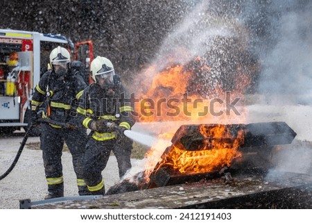 firemen extinguishing with water from a cistern