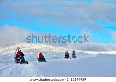 Group of people on a snowmobile in a mountain area. Tourists with snowmobiles on the snow in the mountains in Sovata resort - Romania