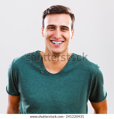 Portrait of content  young man with braces,Young man with braces Royalty-Free Stock Photo #241220431