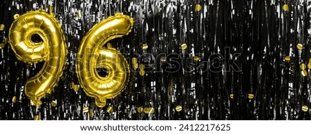 Gold foil balloon number number 96 on a background of black tinsel decoration. Birthday greeting card, inscription ninety-six. Anniversary event. Banner. copy space.