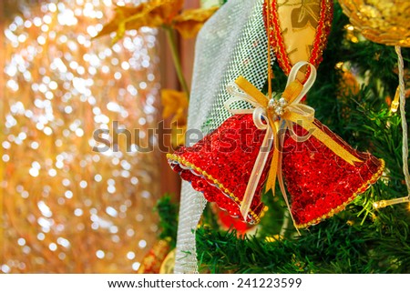 Red Christmas Bell Decoration on Green Cristmas tree with Golden theme Background fully with Bokeh, Thailand cristmas season