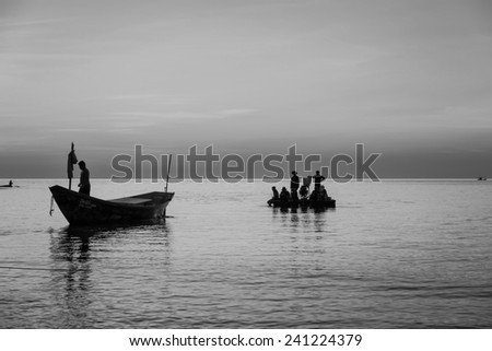 Coastal fishing boats moored at the seaside. With sunset light black and white tones.
