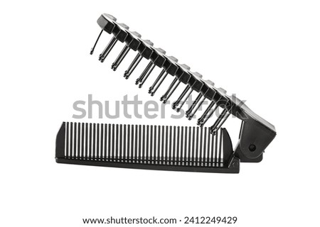 Hair Comb. Sisir lipat. Black double sided folded comb, made by plastic, for travelling, isolated on white background. Close up