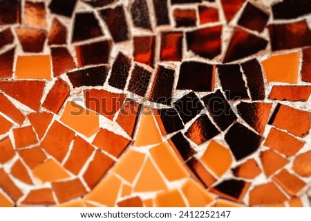 Multicolored orange, yellow ceramic mosaic details. Colorful artwork abstract background. Architecture decoration. Mosaics wall surface macro photo.