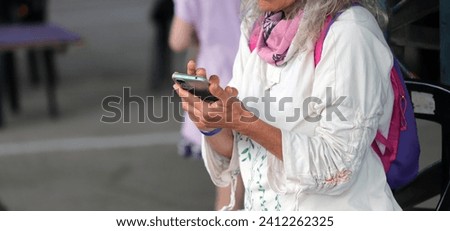
Banner of ederly woman using a smartphone. Close-up of the hands of a 50-year-old lady browsing the internet from her phone. Concept of technology and older people. Background with copy space.