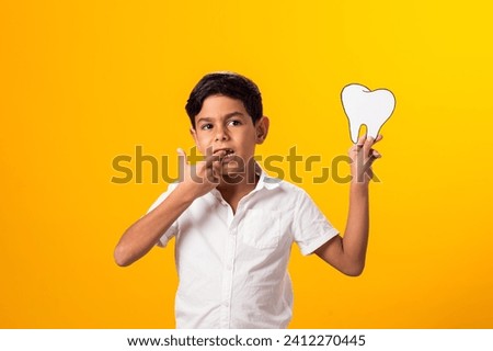 Boy holding papercraft tooth.  Dental health concept