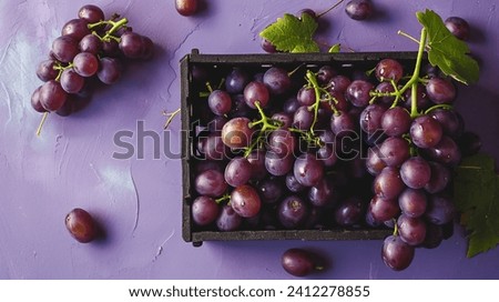 Grapes in a coffin on a purple table