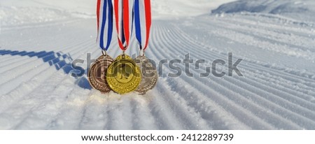 real Gold, silver and bronze medals hanging on red ribbons isolated lying on prepared, new snow ski slope