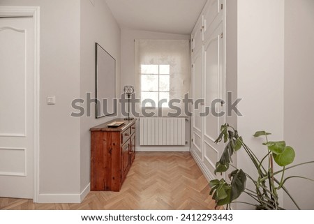 Distributor of a home with built-in white wooden wardrobes, herringbone oak flooring and access doors to other rooms