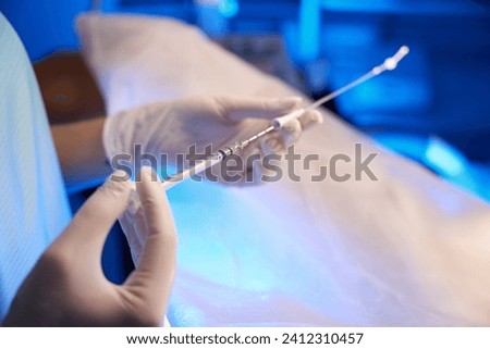 Close up of doctor hands using syringe for artificial fertilization Royalty-Free Stock Photo #2412310457