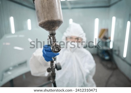 Woman with a paint injection tank in her hands Royalty-Free Stock Photo #2412310471