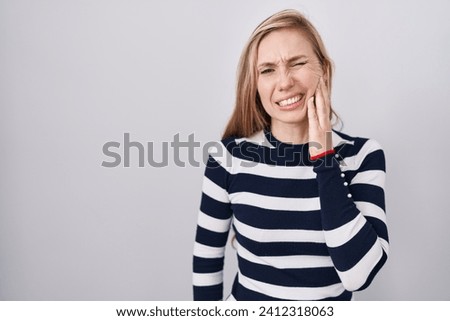 Young caucasian woman wearing casual navy sweater touching mouth with hand with painful expression because of toothache or dental illness on teeth. dentist 