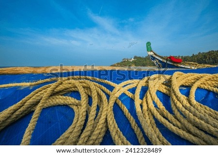Fishing boat and tie ropes on the beach shore.