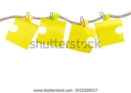 Yellow sheets of notes hanging on a rope on a white background. Sheets are attached with paper clips to a rope isolate