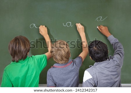 Children, chalkboard and school writing with education, cursive and answer for learning. Back, knowledge and youth development in a study lesson with students in classroom with chalk and solution Royalty-Free Stock Photo #2412342317