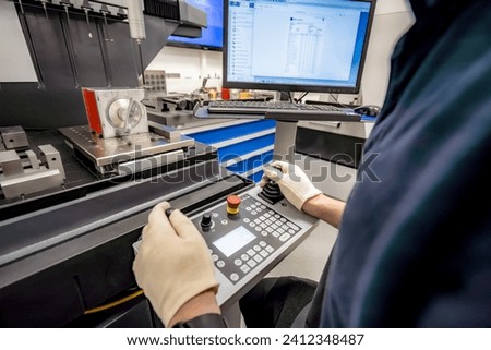 A worker operates a 3D optical measuring machine to ensure high quality and accuracy of manufactured products. Royalty-Free Stock Photo #2412348487