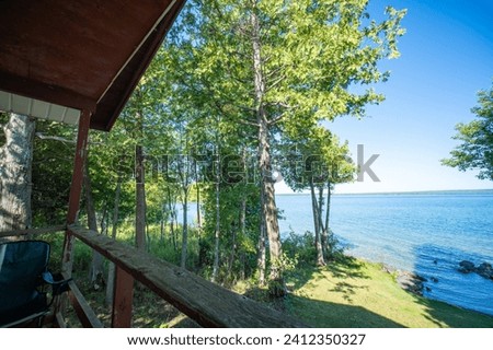 View to the beautiful Lake Manitou from the cabin. Amazing sky line landscape with trees and water. Canadian wilderness. Perfect spot for a holiday. Cottage located on the largest fresh water island. Royalty-Free Stock Photo #2412350327